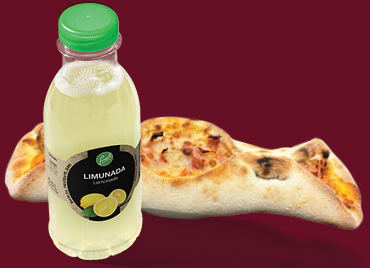 Na slici su boca limunade z brandom Petrol in pečeno pecivo z nadevom, položeni na temno rdečem ozadju. 