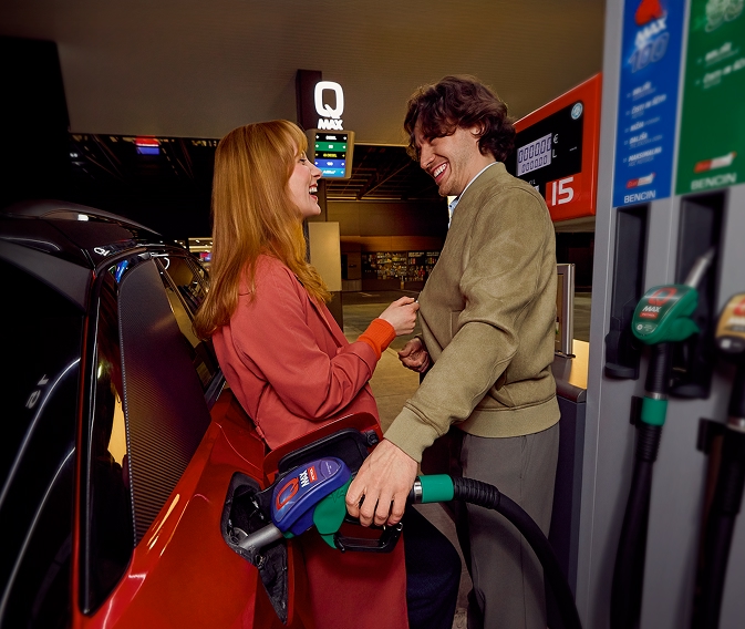 Par toči gorivo Q Max na Petrolovu prodajnom mjestu i opušteno se smije uz automobil.
