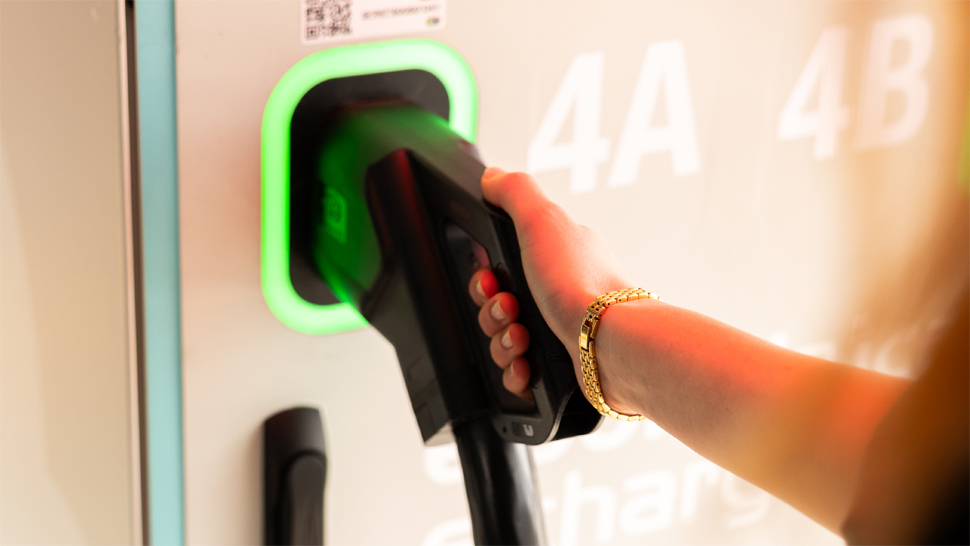 Electric car at a charging station on Petrol premises, powered by renewables, offering a comfortable break for driver.