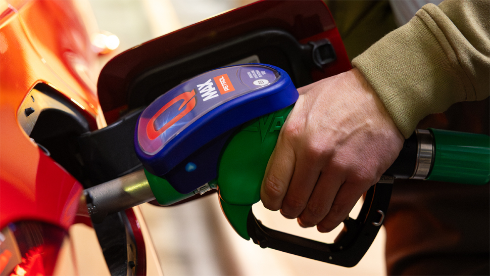 Car fueling with Q Max while the driver enjoys a short break at Petrol and Crodux – efficient fuel for smooth and powerful journeys.