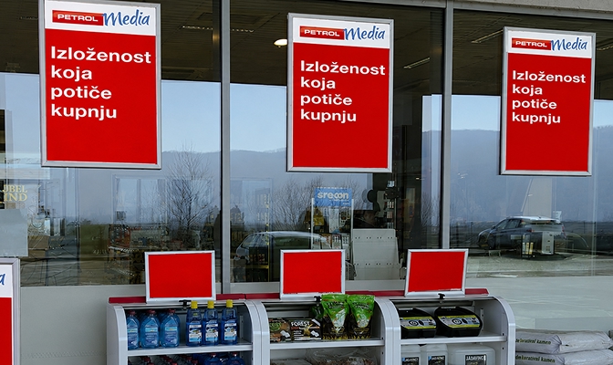 Petrol Media oglasni plakati s natpisom „Izloženost koja potiče kupnju” postavljeni iznad polica s proizvodima u trgovini.